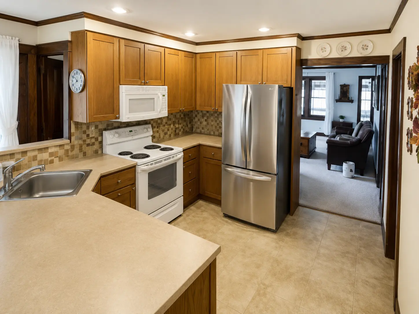 Kitchen with oak cabinets, stainless refrigerator and a pass-through to the living room